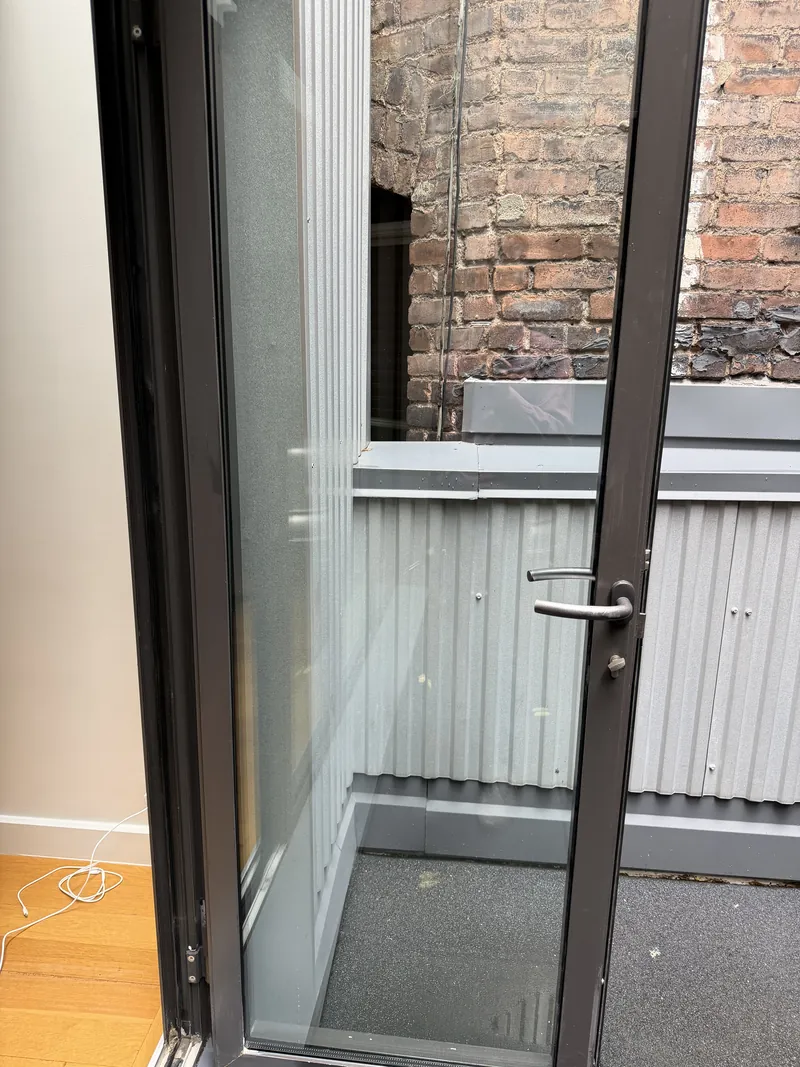 Aluminum and glass balcony door with lever handle and thumbturn