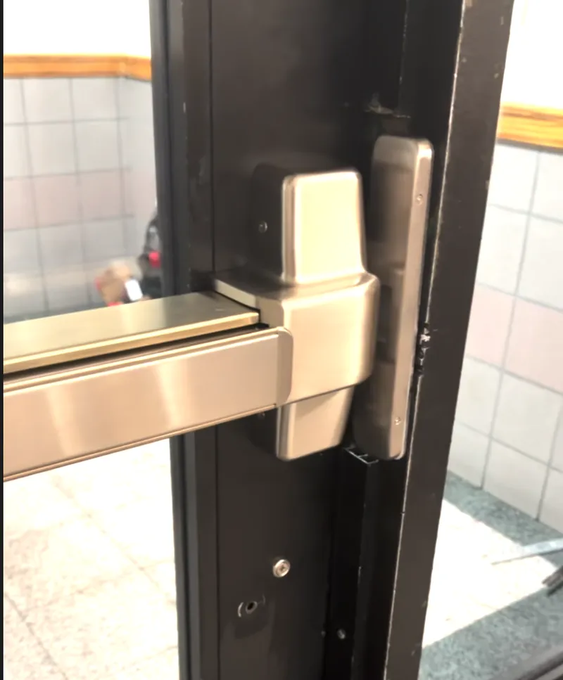 Exit device and fob reader on the inside of a black aluminum building entrance door