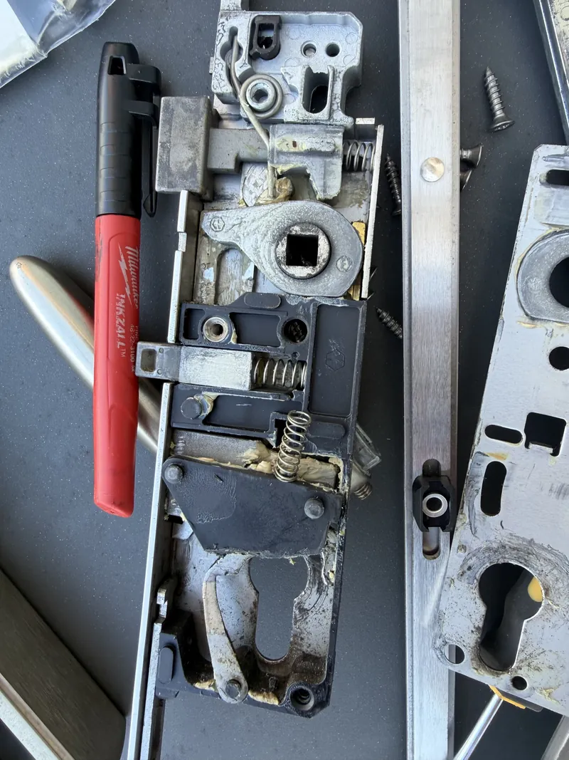 Opened multipoint lock gearbox showing plastic parts, springs and cam