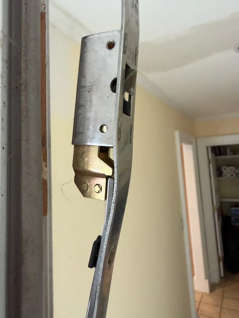 Multipoint hook lock case and bent faceplate removed from a door