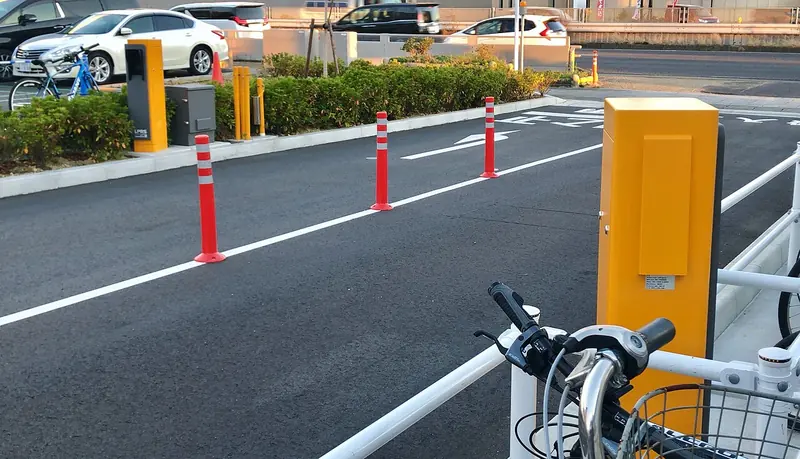 Plate-recognition camera pedestals beside the entrance lanes of a parking lot