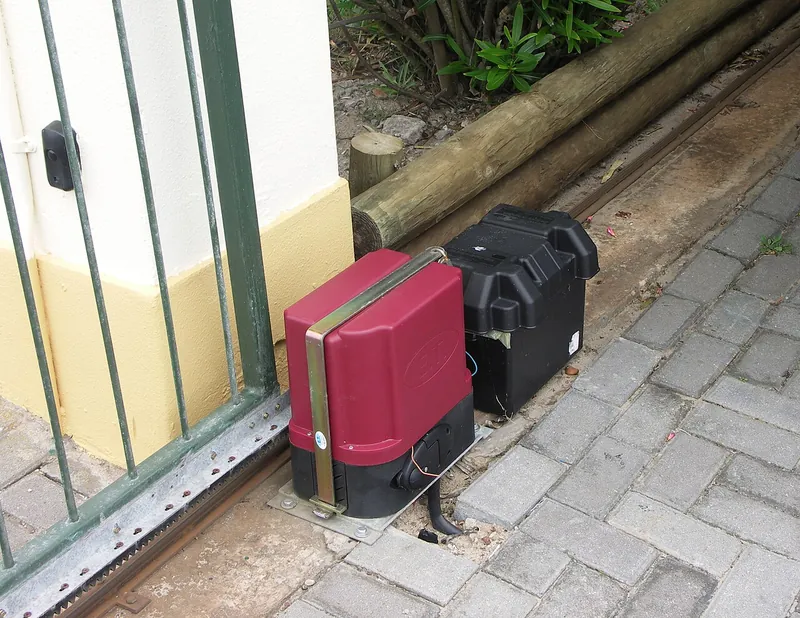 A sliding electric gate with its motor and track visible